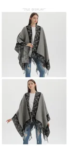 Detail showing grey and black floral jacquard pattern and fringe trim on the shawl poncho