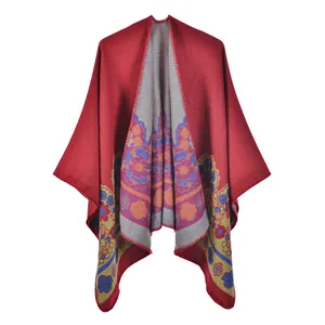 Détail du poncho en tricot bordeaux montrant des motifs floraux et des points overlock