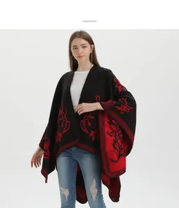Dettaglio ravvicinato della trama jacquard floreale rossa e della morbida maglia del poncho
