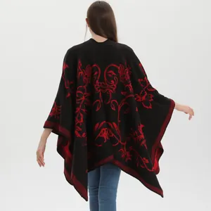 Dettaglio del motivo floreale rosso vintage sullo scialle in maglia spessa nera da donna