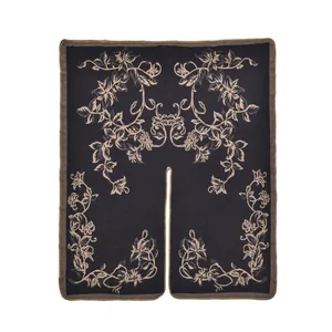 Dettaglio del motivo floreale jacquard e cucitura fine sul poncho in maglia nera
