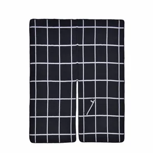 Detail of classic black and white plaid shawl featuring soft knit fabric and neat hem edges