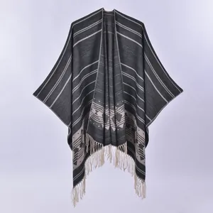 Detailed close-up of double-sided fringe poncho featuring ethnic geometric patterns and stripes