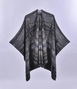 Detailansicht graues Strick-Cape mit aufwendigen schwarzen und beigen geometrischen Mustern