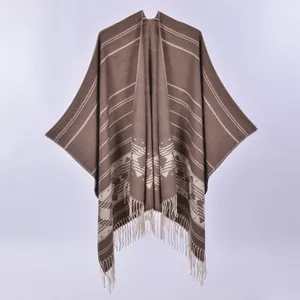Women's knit poncho cape with geometric jacquard pattern and long tassel hem in earth tones