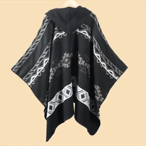 Detail of hooded poncho featuring geometric tribal patterns and thick knit texture