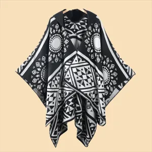 Detail of hooded knit poncho showing black and white bohemian geometric patterns