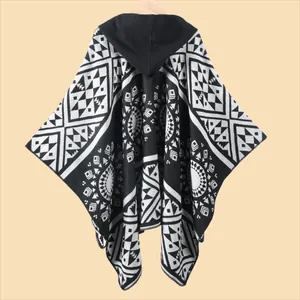 Close-up of black and white geometric pattern knit on a hooded travel poncho with tassels