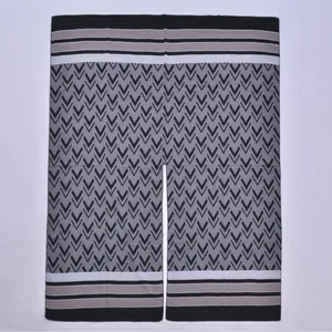 Detailed knit texture of a split shawl with black V-shaped geometric patterns and stripes