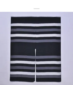 Detail of striped black and white poncho showing fine fringe and soft knit texture