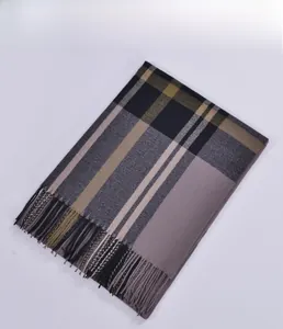 Close-up of classic plaid pattern and fringe detail on warm winter cashmere scarf