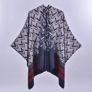 Women double-sided knit shawl poncho with geometric patterns and striped hem detail