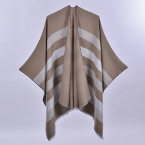 Women's reversible striped poncho cape in brown and grey with elegant fringe detail
