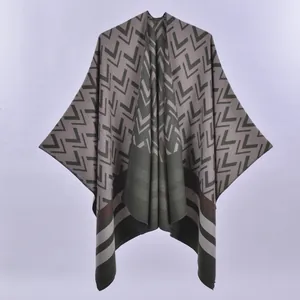 Women's reversible knit poncho with geometric pattern and earthy striped hem details