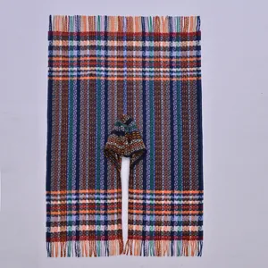 Detailed close-up of ethnic knit poncho fringe with colorful plaid patterns