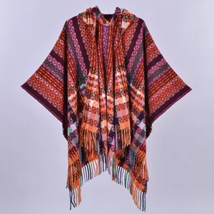 Ethnic hooded poncho with colorful plaid patterns and fringe trim for a boho winter look