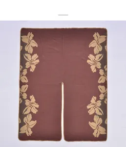 Détail du poncho en cachemire marron avec motif floral jacquard et design fendu sur les bords