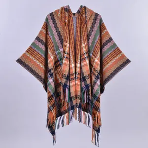 Detailed view of colorful geometric knit pattern and soft fringe on the hooded poncho