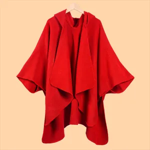 Detailed view of the red knitted poncho featuring a hood and thick textured fabric