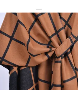 Detailed view of caramel plaid shawl featuring a unique cross-strap knot design and woven texture
