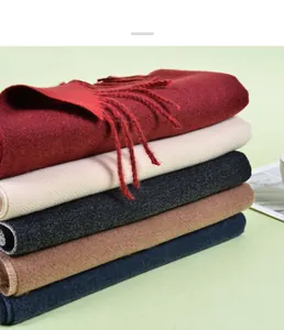 Stacked pashmina scarves in five colors showing thick cashmere texture and fringe detail