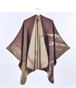 Dettaglio di un poncho in maglia con motivo a foglie jacquard double-face e bordo morbido