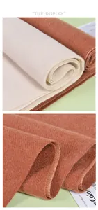 Detail view of thick cashmere texture and twill weave in beige and caramel tones