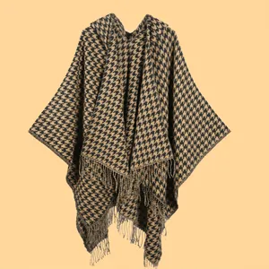 Detail of classic houndstooth knit shawl featuring long fringe tassels and a soft texture
