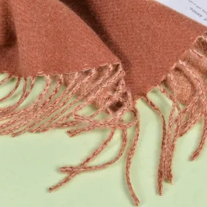 Detail of caramel faux cashmere scarf showing twill weave texture and handmade tassels