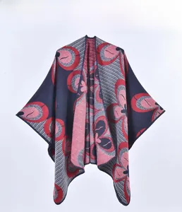 Detail of red and navy knitted poncho with abstract jacquard floral patterns for women