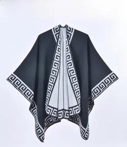 Détail d'un châle en tricot noir avec motif grec géométrique blanc sur les bords