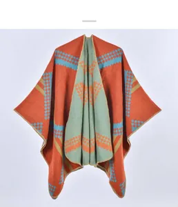 Close-up of knit shawl detailing orange and blue geometric check patterns and fine stitching