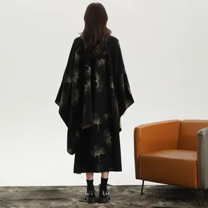 Dettaglio dello scialle nero con motivi di foglie di ginkgo dorate e ricami eleganti