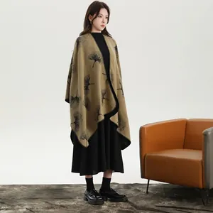 Dettaglio del poncho in maglia kaki con eleganti motivi jacquard di foglie di ginkgo