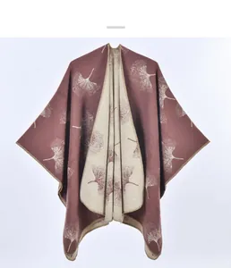 Dettaglio della mantella in maglia con motivi di foglie di ginkgo e bordi rifiniti