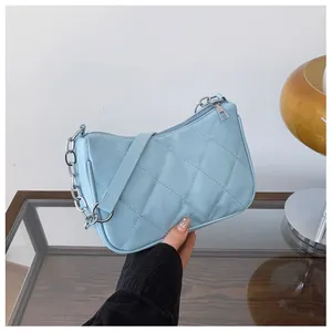 Détail du sac à main matelassé bleu clair avec chaîne argentée et fermeture éclair