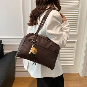 Deep brown faux leather tote bag with a baseball charm shown on a fashion model