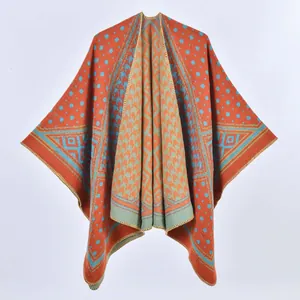 Dettaglio di scialle in maglia etnica con motivi geometrici vivaci arancioni e blu
