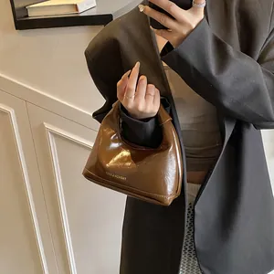 Sac à main hobo marron brillant en forme de demi-lune avec texte blanc pour l'automne
