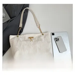 Detail of white wrinkled leather shoulder bag with gold deer charm and metal chain