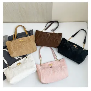 Flat lay of vintage pleated tote bags in five colors with metal chain shoulder straps