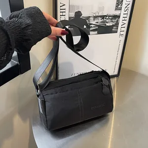 Sac bandoulière en nylon noir imperméable avec compartiments zippés et sangle large