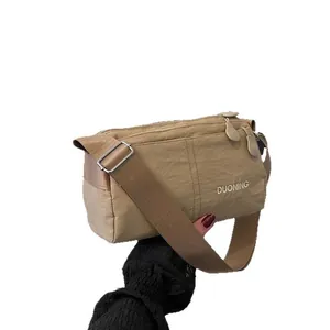 Sac bandoulière imperméable en nylon kaki avec plusieurs compartiments et sangle