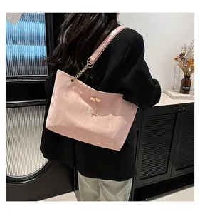 Side view of pink pleated tote bag with golden deer charm and chain shoulder strap