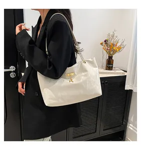 Detailed shot of white textured tote bag featuring gold chain strap and deer charm