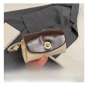 Detail der braun-beigen Kunstledertasche mit goldenem Drehverschluss und verstellbarem Riemen