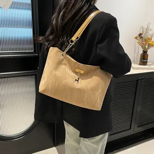 Retro khaki tote bag with pleated texture and chain strap, shown on a model's shoulder