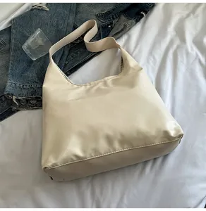 Detailed top view of a large cream tote bag on white fabric with casual props
