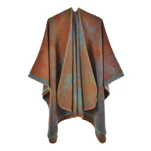 Women's knit poncho with orange and blue ginkgo leaf pattern and stitched edges
