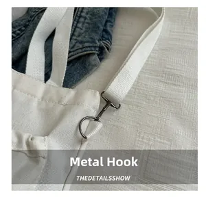 Close-up of vintage hardware hook on a minimalist white canvas shoulder bag